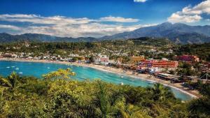 Blick auf einen Strand mit Stadt und Berge in der Unterkunft Departamentos La roca D2 in La Peñita de Jaltemba + 17 Fotos