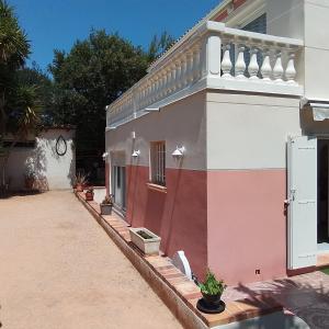 a pink and white house with a courtyard at Villa L'Audaline in Roquebrune-sur-Argens