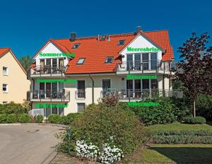 a large white building with a red roof at Landhaus Residenz Ostsee Meeresbrise in Insel Poel +11 photos