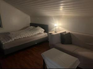 a small room with a bed and a couch at Veslefrikkveien in Tromsø