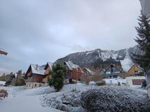 a snow covered village with houses and a mountain at Chalet au cœur de la station in Thollon