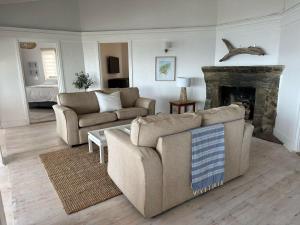 a living room with two couches and a fireplace at Waters Edge Beach House in Sea View