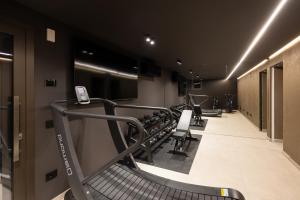 a gym with a row of treadmills and machines at Stemor Visionary Apartments in Desenzano del Garda