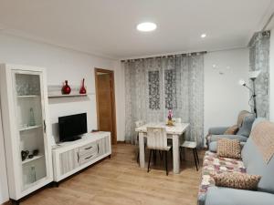 a living room with a television and a table and chairs at San Andres 14 in Teruel
