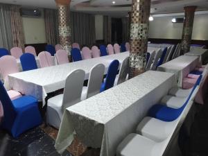 a long table and chairs in a room at Super Paradise Hotel in Kampala