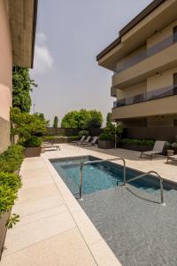 a swimming pool in front of a building at Stemor Visionary Apartments in Desenzano del Garda