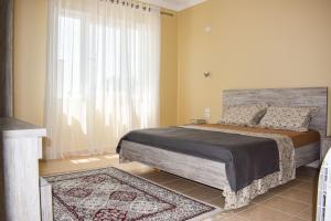a bedroom with a bed and a large window at J & J Holiday Home Vala Mar in Hamallë