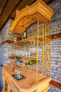 a yellow shelf with glasses and a bottle of wine at Nalagarh House by EdenHomes in Manāli