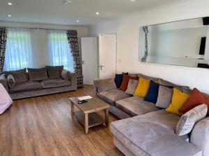 a living room with two couches and a table at Pencoed House Estate (Cardiff) in Cardiff
