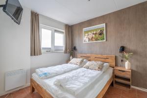 a bedroom with a bed and a television in it at Appartementencomplex Juliana 142 in De Koog