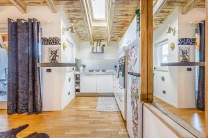 a kitchen with white walls and wooden ceilings at Unconventional BnB near Linate - Supreme Meme Loft in Milan