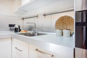 a kitchen with white cabinets and a sink at Unconventional BnB near Linate - Supreme Meme Loft in Milan +31 photos