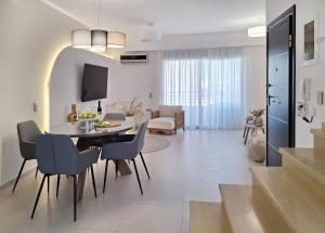 a living room and dining room with a table and chairs at Lux home in central location in Ierapetra