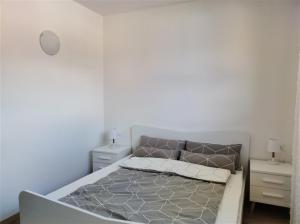 a white bedroom with a bed and two night stands at IseoLakeRental - Incanto Blu in Clusane sul Lago +9 photos