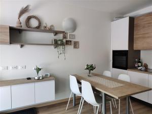 a kitchen with a wooden table and white cabinets at IseoLakeRental - Incanto Blu in Clusane sul Lago