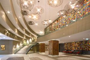 a lobby with escalators and stained glass windows at Grand Hotel Djibloho in Djibloho
