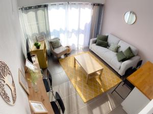 a living room with a couch and a table at L'Ecrin Duplex Piscine Proche Plage Palavas in Palavas-les-Flots