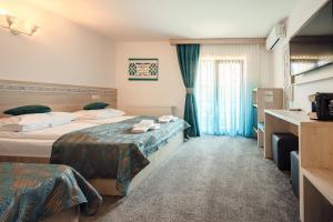 沃拉内特Casa Elena - Resort & SPA的一间有两张床和一扇窗户的酒店房间