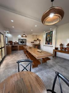 土巴迪亚劳Ecolodge La Grande Tortue - Maison d'hôtes的一间有大木桌和椅子的餐厅