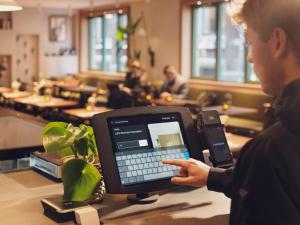 a man is using a computer on a table at Townhouse Den Haag in The Hague