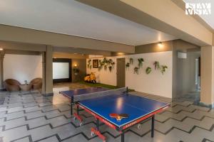 a ping pong table in the middle of a room at Mehta Mansion by StayVista - A Villa with a Swimming Pool and Pool Table in Lonavala
