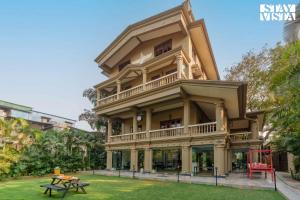 a large building with a table in front of it at Mehta Mansion by StayVista - A Villa with a Swimming Pool and Pool Table in Lonavala