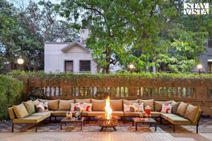 a patio with a couch and a fire pit at Mehta Mansion by StayVista - A Villa with a Swimming Pool and Pool Table in Lonavala