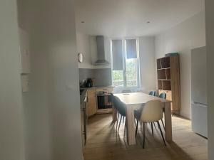 a kitchen with a table and chairs in a room at Grand appartement proche gare in Sens