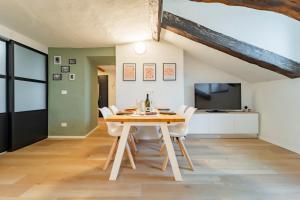 a dining room with a table and chairs and a tv at La Dimora di Barbaroux in Cuneo