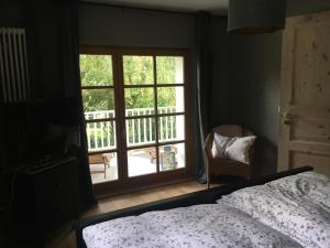 a bedroom with a bed and a window with a balcony at Waldblick in Bleckede