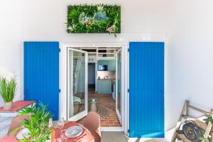 Una habitación con puertas corredizas azules y una cocina. en Appart le Grand Bleu Saint Aygulf, en Fréjus