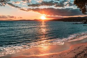 a sunset on a beach with the ocean at Camping Au Paradis des Campeurs Premium in Roquebrune-sur-Argens