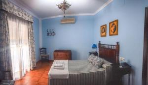 a blue bedroom with a bed and a couch at CasaBlancaflor in Peñaflor