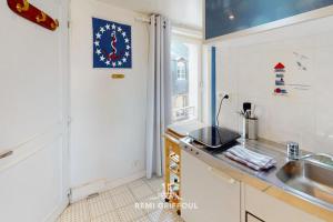 una cocina con fregadero y encimera en Racing the Wind Breathtaking Port View 2 pers, en Honfleur
