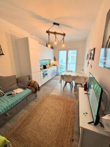 a living room with a couch and a table with a tv at Appartamento San Marco in Cesenatico