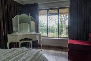 a bedroom with a dressing table and a mirror at Rosedale Self Catering Cottage with pool and large entertainment BBQ area in Rosetta