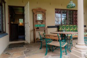 a dining room with a table and chairs and a chandelier at Rosedale Self Catering Cottage with pool and large entertainment BBQ area in Rosetta
