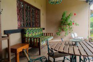 a patio with a table and a bench and a table and chairs at Rosedale Self Catering Cottage with pool and large entertainment BBQ area in Rosetta