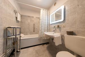 a bathroom with a sink toilet and a bath tub at Ferienwohnung "Weserblick" Columbus Center in Bremerhaven +39 photos