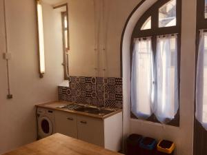 Il comprend une petite cuisine avec une cuisinière et une fenêtre. dans l'établissement Le Lion d'Or chb double wifi 4, à Écueillé