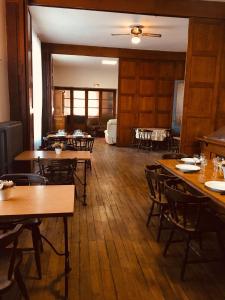 une salle à manger avec des tables et des chaises en bois dans l'établissement Le Lion d'Or chb double wifi 4, à Écueillé