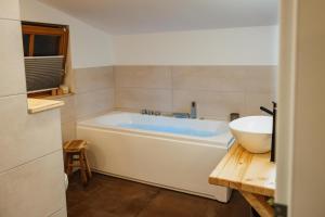 a bathroom with a white tub and a sink at Lodge mit Sauna & Seeblick für Naturliebhaber in Diemelsee +18 photos