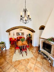 a dining room with a table and a fireplace at Casa do Avo Zezinho in Telheiro