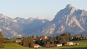 une chaîne de montagnes avec des maisons et des arbres devant elle dans l'établissement Ferienwohnung Bamberger Gipfelblick, à Hopferau
