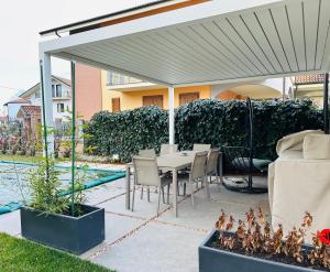 a patio with a table and chairs under a white canopy at Dimora San Michele in Almese