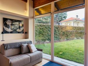 a living room with a couch and a large window at Dimora San Michele in Almese