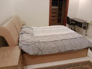 a bed in a room with a desk and a chair at شقة جميلة in Irbid