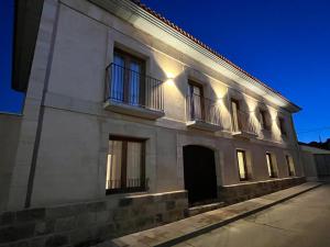 a white building with balconies on a street at Casa Rural en Zamora Casa Bamba in Villalobos