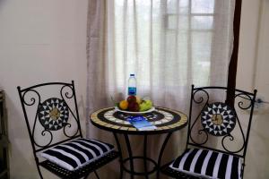 a table with a bowl of fruit and a bottle of water at Tiny Boutique House Koh Kood in Ban Lak Uan +6 photos