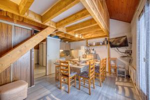 a kitchen and dining room with wooden ceilings and a table and chairs at Les Balcons de la Sagne - Au Pied des Pistes in LʼHuez